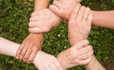 6 Hände im Kreis zur Selbsthilfe