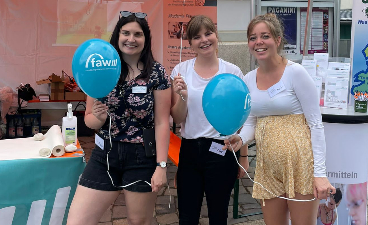 Drei Frauen lächeln mit FAW Ballons in die Kamera.