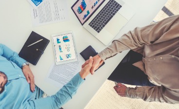 Auf dem Foto sind zwei Personen, die sich die Hand schütteln.