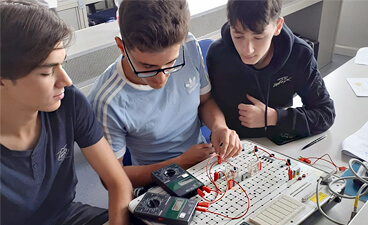 Teasersbild: Drei Berufsschüler arbeiten im Elektrofachlabor im AZZ
